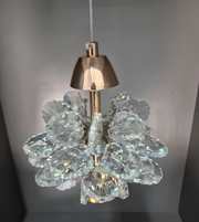 Crystal chandelier with gold fixture on a gray background
