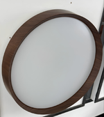 Round ceiling light fixture with wooden frame on a white wall