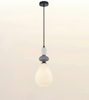 A modern pendant light with a black metal canopy and cord, featuring a textured gray decorative collar and a large, ribbed white glass shade that glows with warm light, set against a plain off-white background.