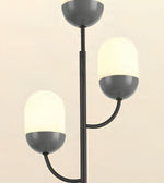 A modern three-light floor lamp with a matte black metal frame and frosted white glass shades, shown against a plain light beige background.