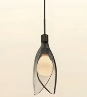 A modern pendant light with a dark gray smoked glass shade and a black metal fixture, shown against a plain off-white background.