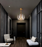 Modern hallway with a decorative chandelier, white armchair, and dark walls.