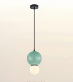 A modern pendant light fixture with a matte mint green upper globe, a black suspension rod and canopy, and a smaller glowing white lower globe, shown against a soft off-white gradient background.