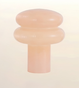 A translucent peach-colored silicone or rubber cap with a rounded, tiered design and a cylindrical base, shown against a solid off-white background.