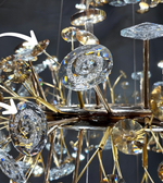 Close-up of a luxurious chandelier with crystal and gold details against a dark background