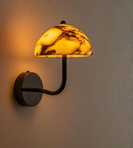 Modern amber marble dome wall light with warm glow mounted on textured wall