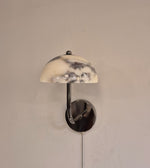 Elegant white marble dome wall light with metal arm mounted on interior wall
