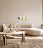 Modern living room with a beige sofa, wooden coffee table, and wall-mounted light fixture.