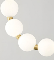 Ceiling light fixture with white spherical lights and gold accents on a gray background