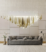 Modern living room with a gray sofa and a large decorative chandelier.
