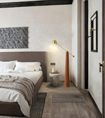 Modern brass arc floor lamp beside bed in contemporary bedroom