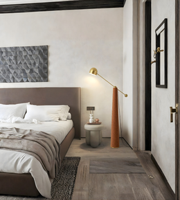 Modern brass arc floor lamp beside bed in contemporary bedroom
