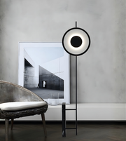 Contemporary ring-shaped LED standing lamp beside sofa in living room