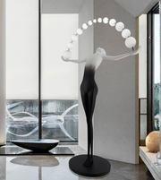 Sculptural floor lamp by Daya Worldwide featuring a modern, artistic statue design with a sleek base and ambient lighting.