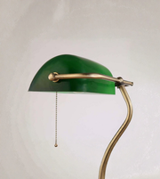 Detailed view of green glass shade with brass fittings and pull chain