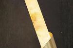 Modern marble wall sconce with brass spiral accent glowing warmly
