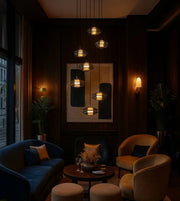 Modern pendant lighting over elegant lounge with velvet armchairs, wall art, and decor