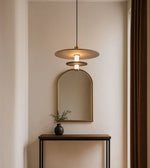 Modern pendant light over console table with arch mirror and minimalist decor in neutral room